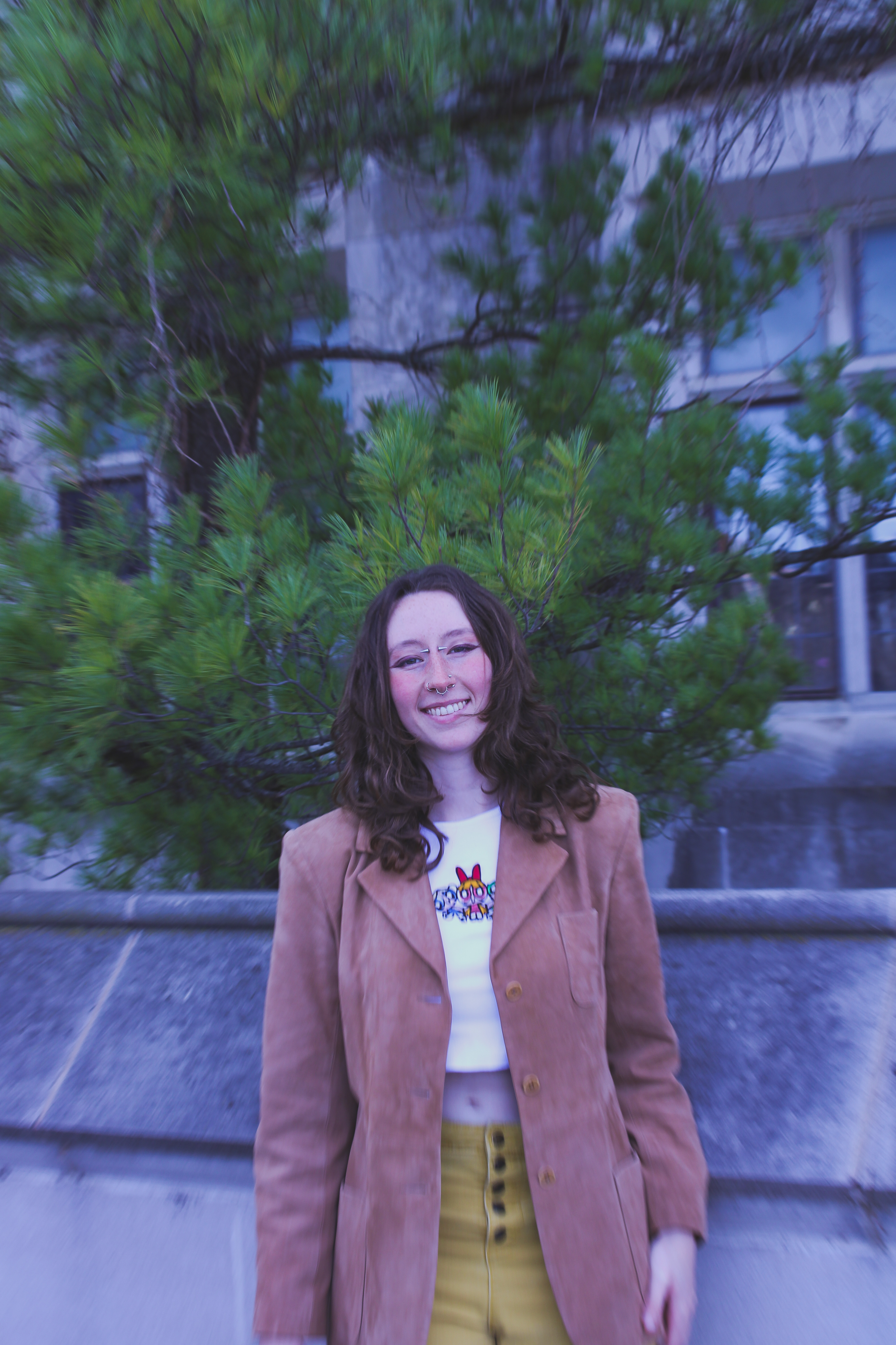 Person wearing suede blazer, yellow pants, and Power Puff Girls graphic tee.